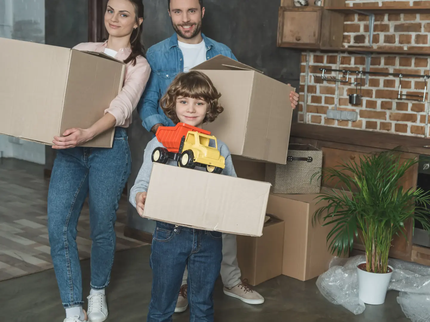 Family carrying cartons into their new home on moving day in Dubai